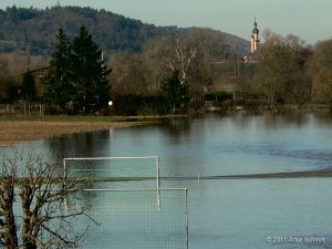 Hochwasser am 16.01.2011. Blick über den überfluteten Fußballplatz auf die Kirche von Eibelstadt.