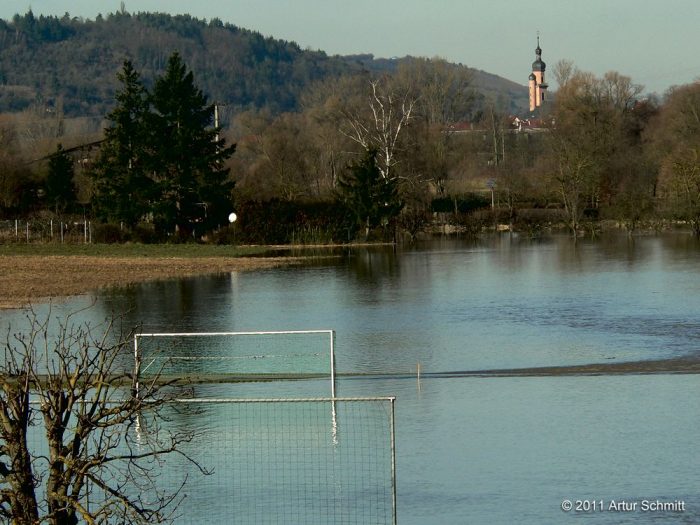 Hochwasser am 16.01.2011. Blick über den überfluteten Fußballplatz auf die Kirche von Eibelstadt.