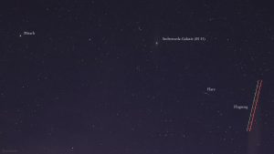 Andromeda-Galaxie (M 31), Flare eines Satelliten und Strichspur eines Flugzeugs am 11. März 2024 am Nordwesthimmel von Eisingen.