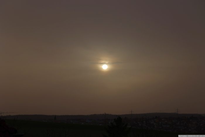 Sonne hinter Saharastaub am 30. März 2024 (Karsamstag) am Westhimmel von Eisingen.