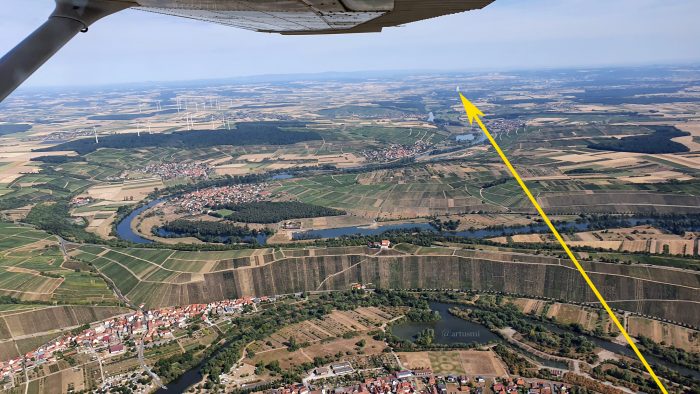 Gelber Pfeil zeigt unseren Standort in Nordheim am Main (unten) und unsere Blickrichtung auf das ehemalige AKW Grafenrheinfeld (oben) - Distanz: 15,4 km