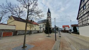 Obere Dorfstraße mit kath. Pfarrkirche St. Bartholomäus in Kist am 19. Dezember 2025