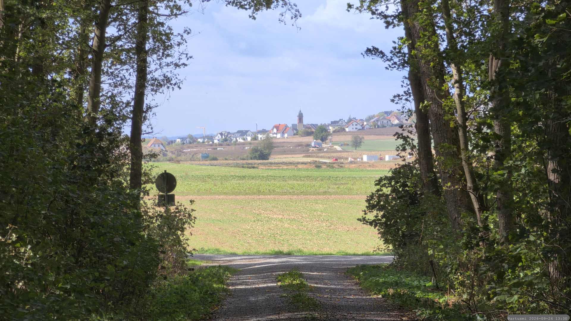 Wir verlassen den Wald und blicken auf Helmstadt im Lkr. Würzburg