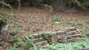 Die steinerne Fassung der Moorsquelle wurde 1968 errichtet. Seit von hier aus kein Wasser mehr zum Längsee fließt, führt das Kleindenkmal ein tristes Dasein.